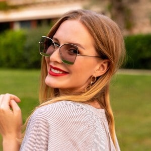 Moderner Frau mit Sonnenbrille bei schönem Wetter im Park.