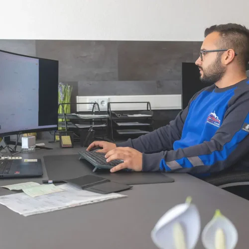 Kfz-Service-Mitarbeiter bei der Büroarbeit in der Autowerkstatt Kaiser Fulda, Verwaltung und Planung im Autohaus.